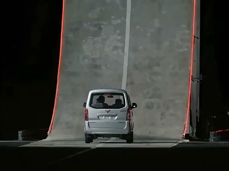 A silver minivan lined up at the foot of a tall curved stunt ramp with red edge lights, a frame from an AI flying car sample video